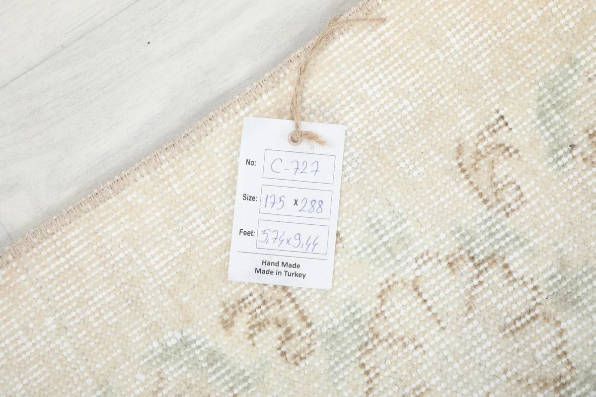 Photo of the rug's label with size and origin details, placed on the back of the vintage Anatolian rug.