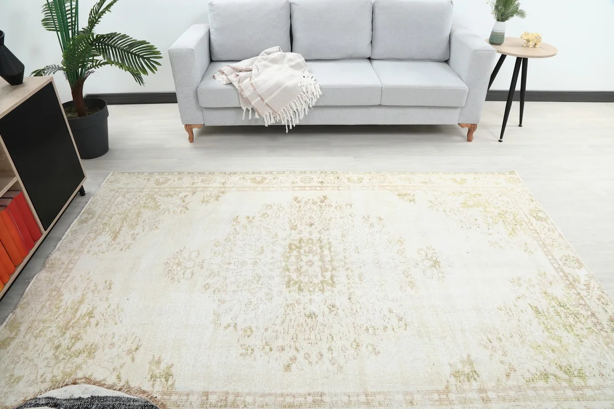 Overhead view of the vintage rug in a living room, highlighting its placement under a sofa.