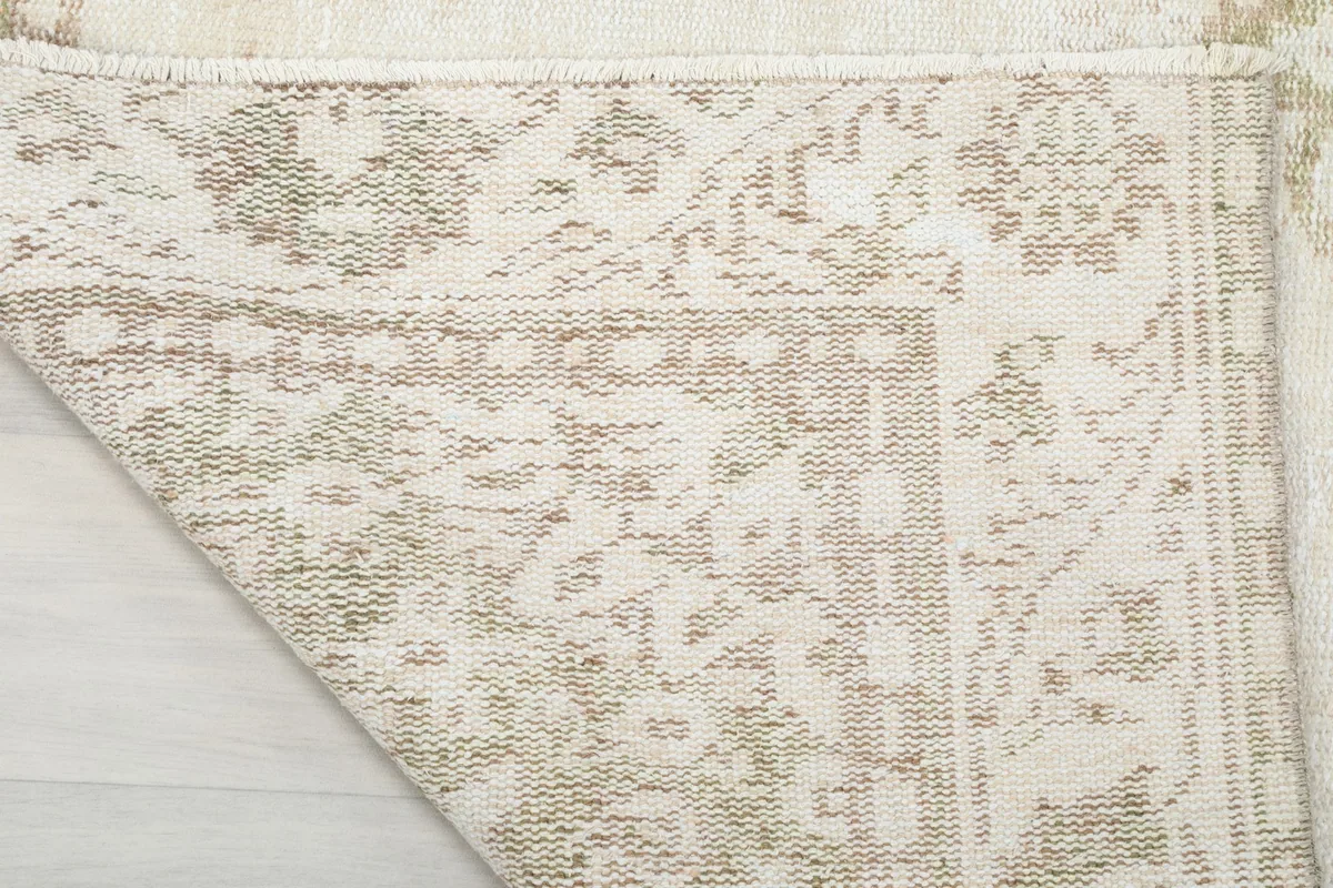Close-up of the rug's reverse side, showing the hand-knotted cotton foundation and wool knots.