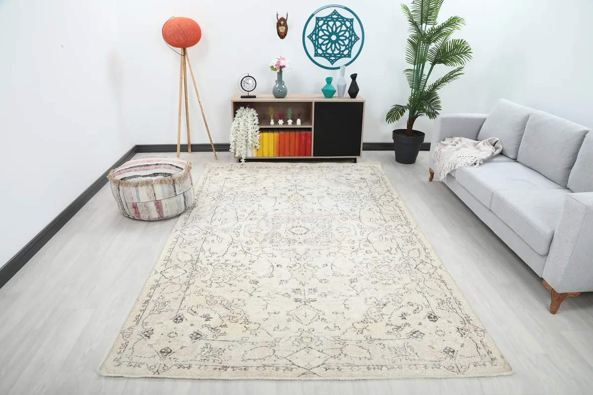 Ivory and gray floral medallion rug displayed in a living room setting with a sofa and decor.