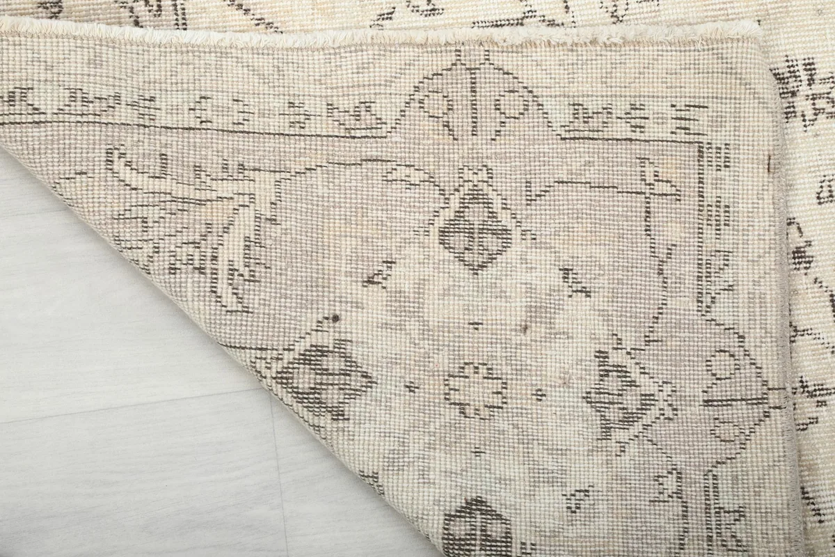 Underside view of the rug, showing the hand-knotted cotton foundation and the reverse of the pattern.