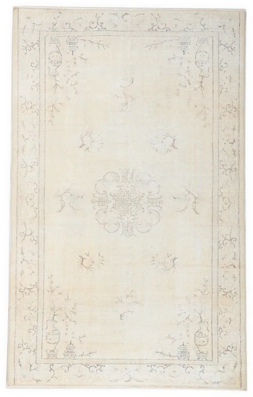 Full overhead view of a beige vintage Anatolian rug with a subtle medallion on a white background