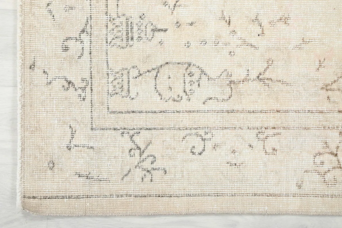 Detailed view of the corner border design and subtle patterns near the edge of the rug
