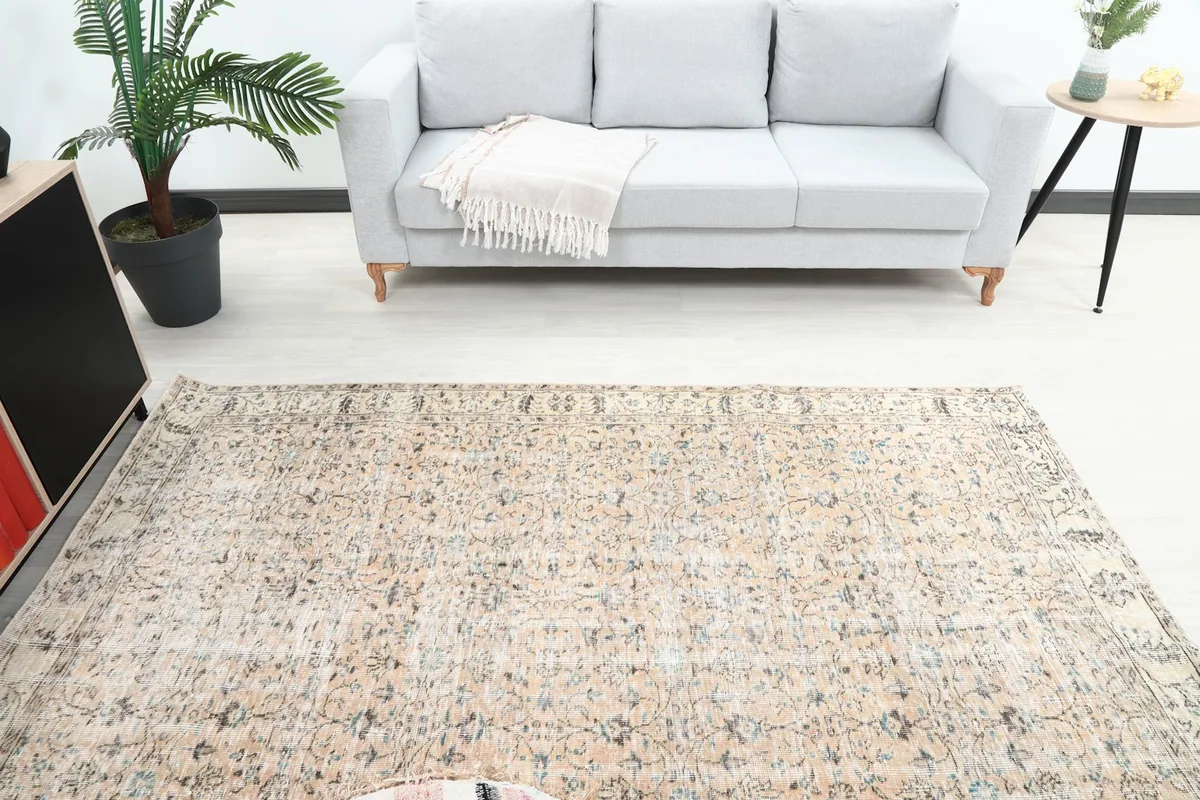 Overhead view of the rug in a living room, positioned in front of a light gray sofa.