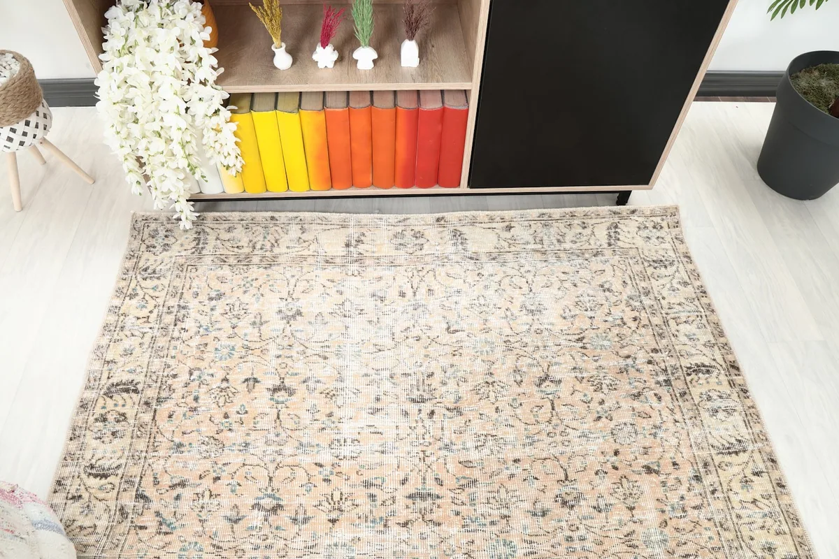 Angled view of the rug in a room, highlighting the distressed beige and blue patterns.