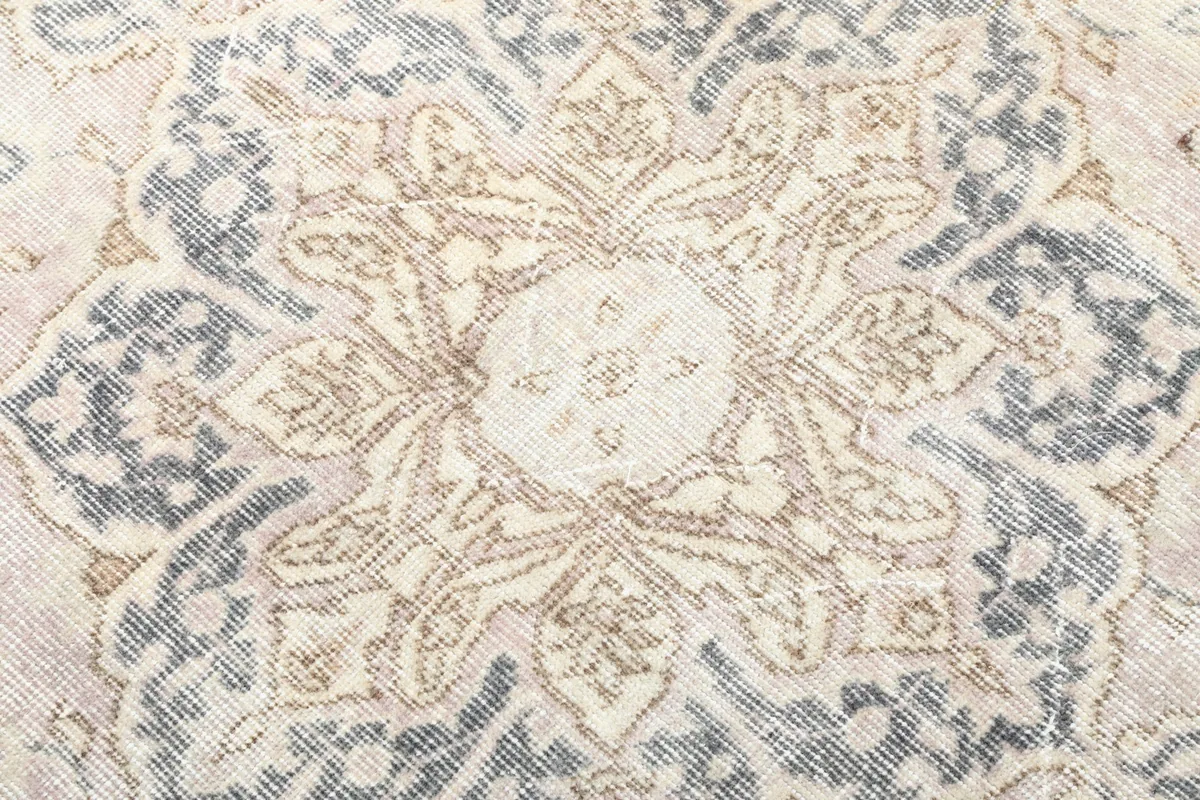 Detailed view of the central medallion design with beige and gray tones