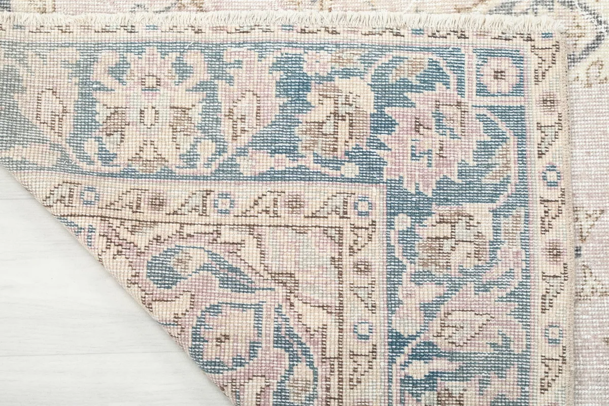 Corner of the rug folded to show the hand-knotted wool pile and cotton foundation