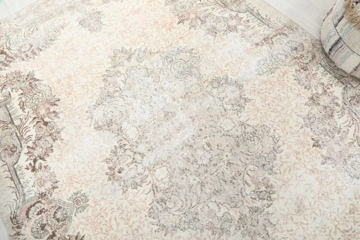 Detailed close-up of the central medallion and faded floral patterns of the rug