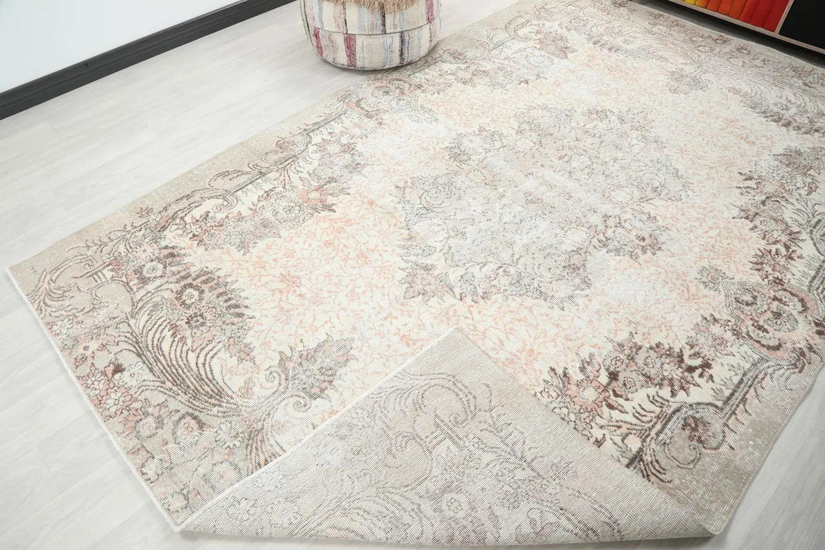 Corner of the rug folded back, showing the cotton foundation and reverse side of the knotting