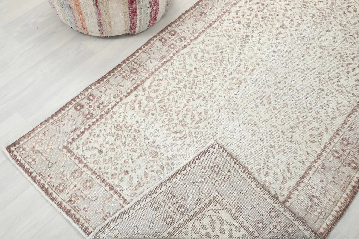 View of a corner of the rug folded back, showing the cotton foundation and reverse side