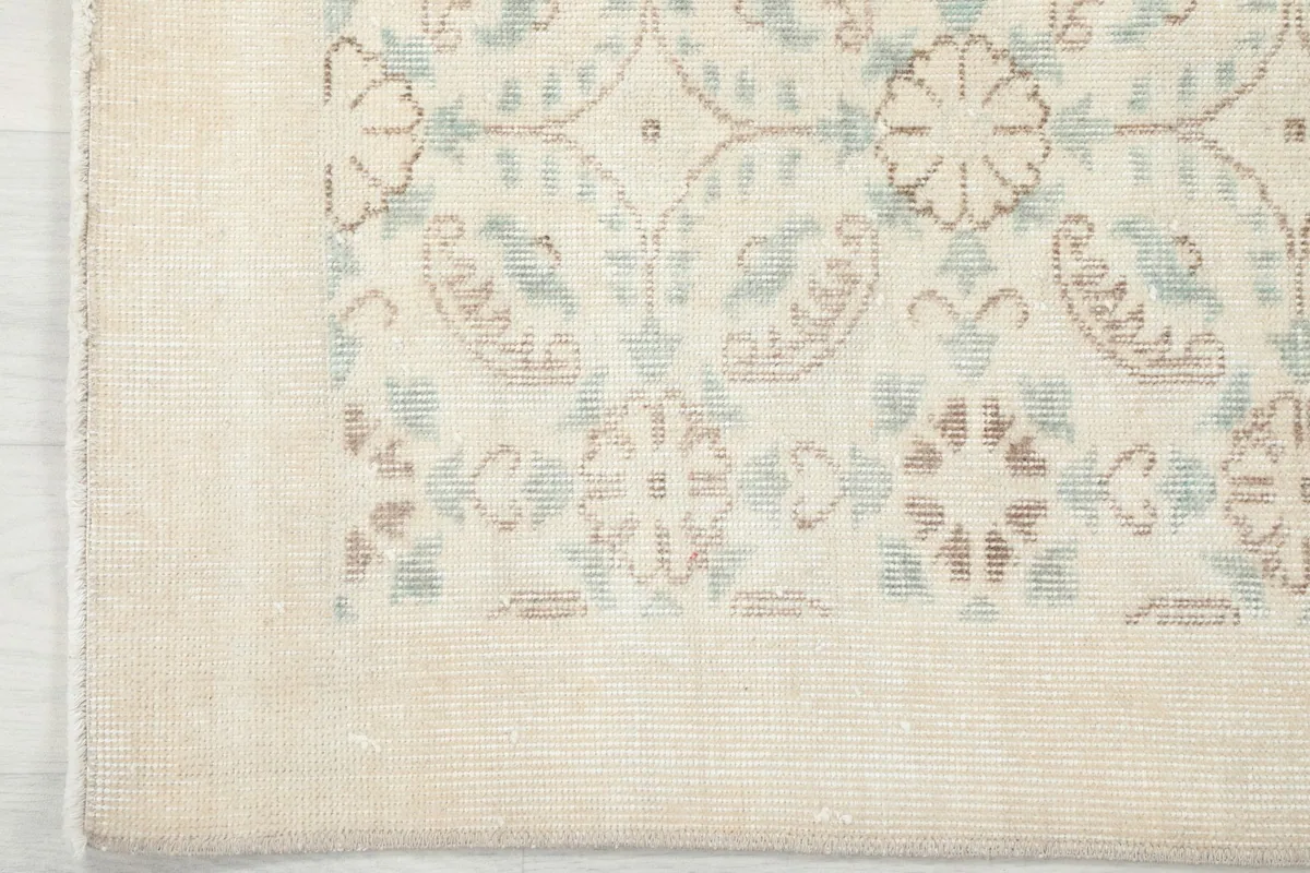 Close-up of the subtle ivory border and edge of the vintage rug