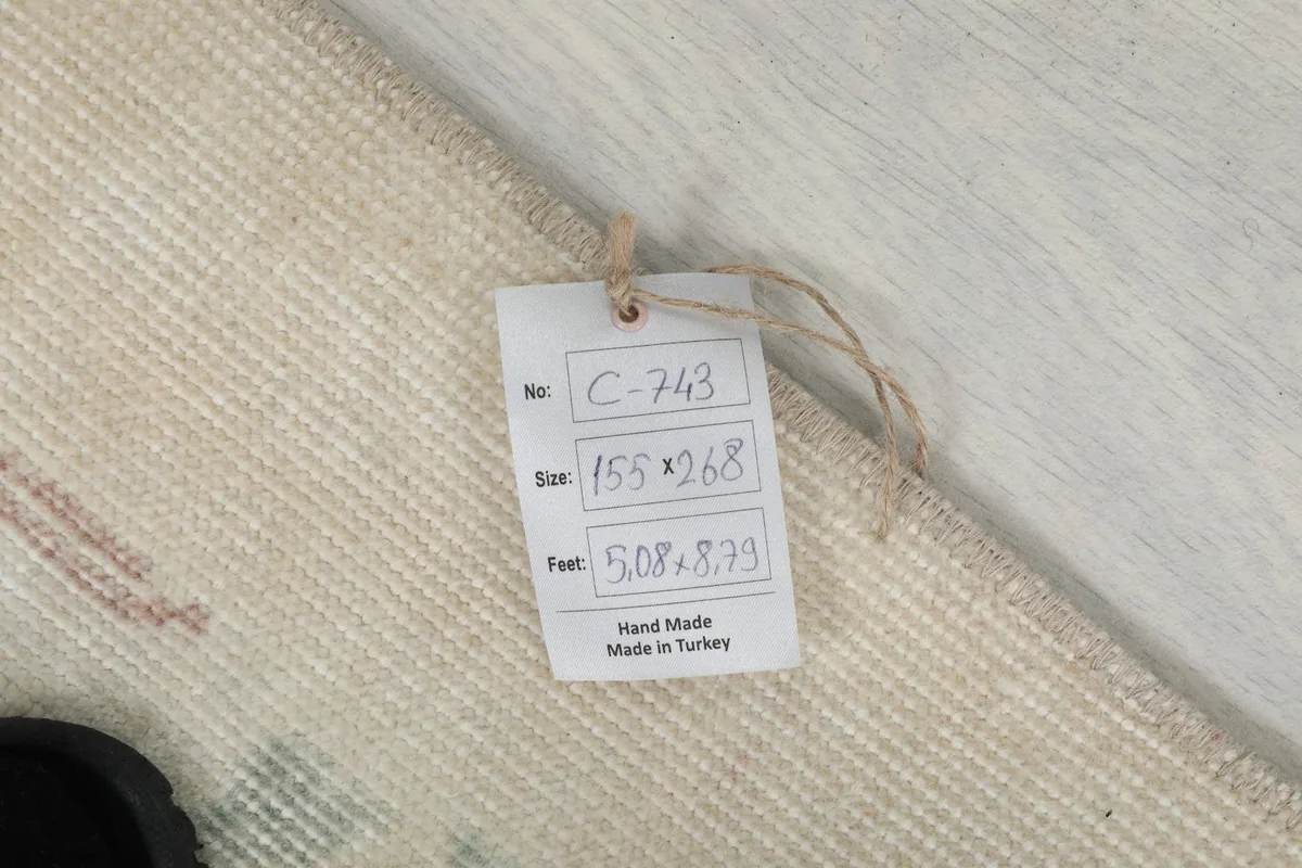 Tag displaying the rug's size in centimeters and feet, origin, and hand-made nature