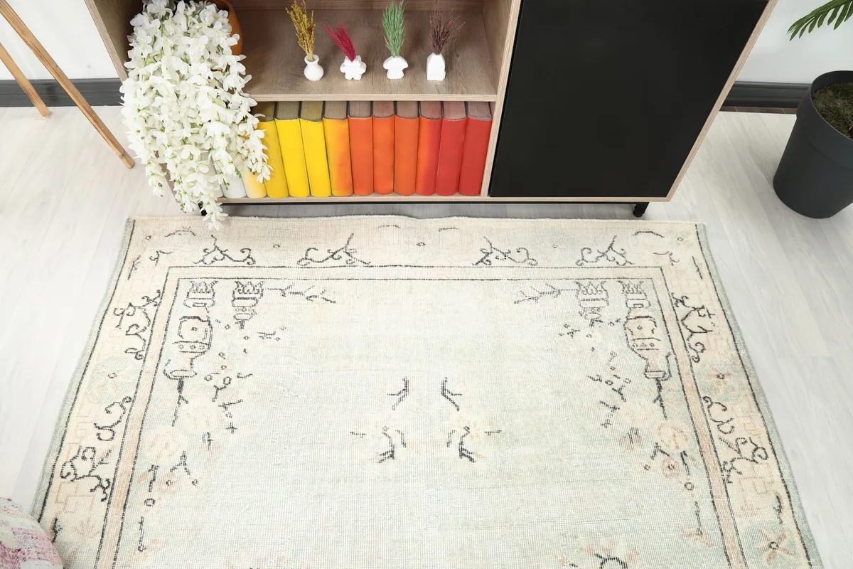 Partial view of the rug's upper section in a room, showing the border detail and field motifs.
