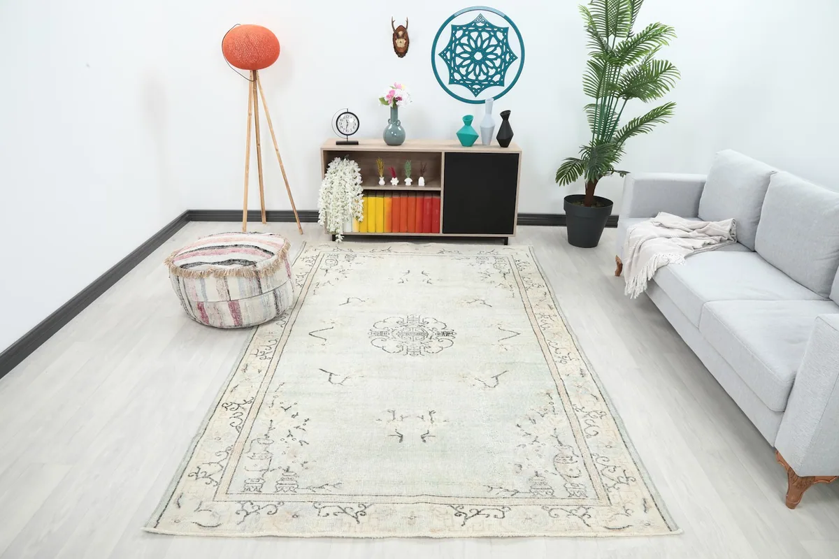 Vintage Anatolian rug displayed in a bright living room setting with a light gray sofa and modern decor.