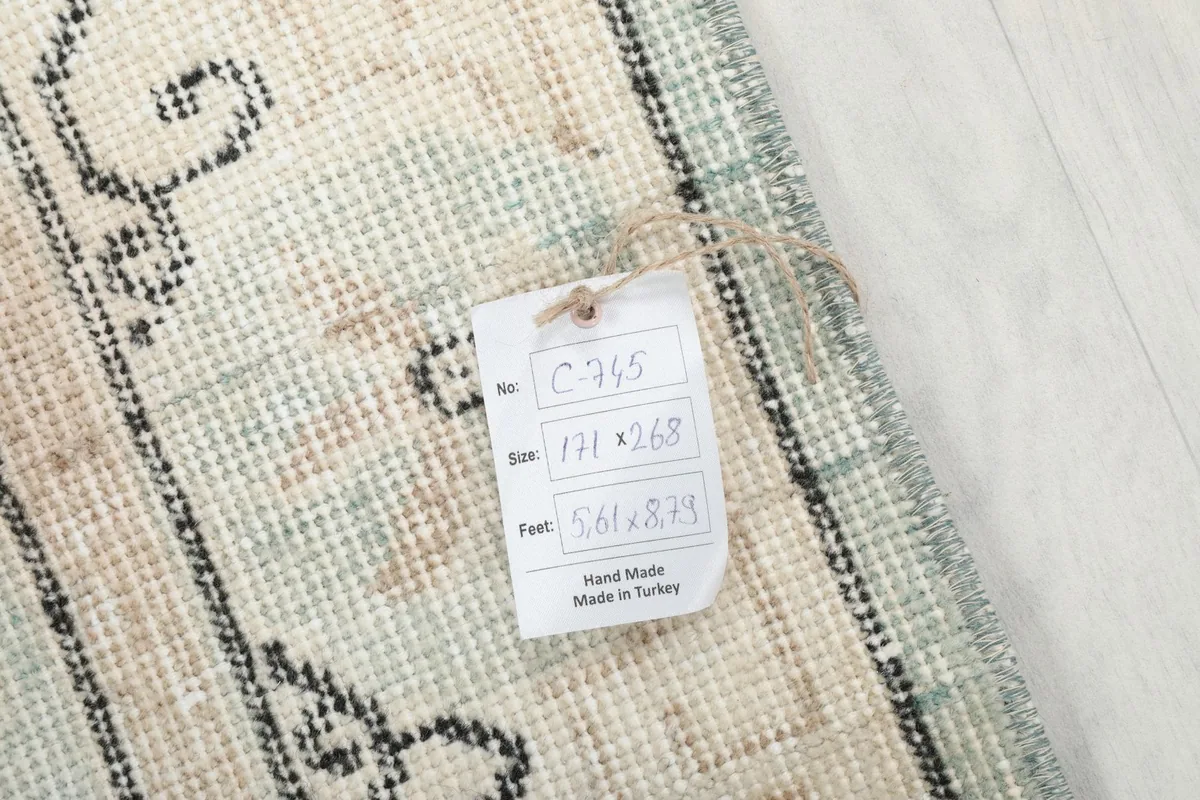 Close-up of the rug's underside with a size tag displaying dimensions in cm and feet.