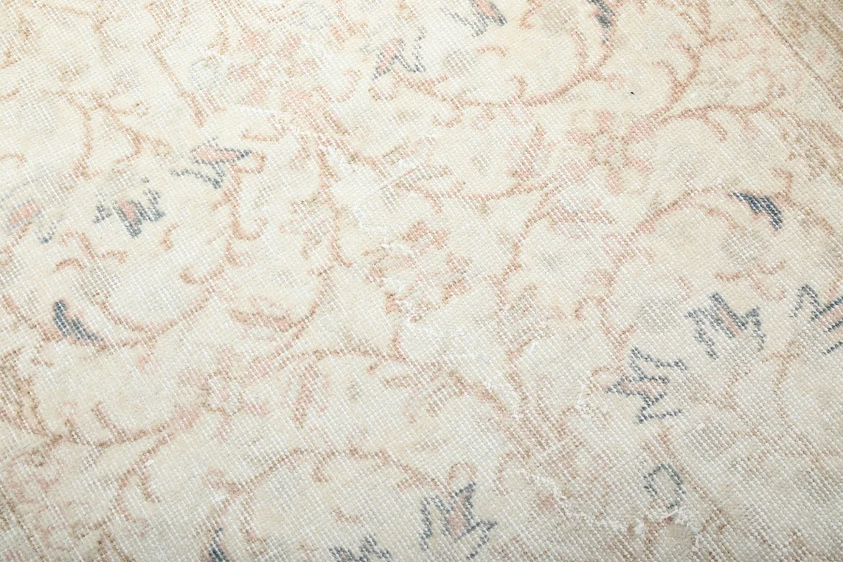 Close-up of the low wool pile, showing the texture and subtle color variations of the vintage rug
