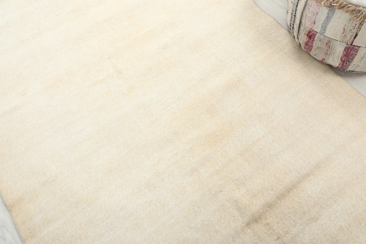 Close-up detail of the ivory wool pile, showing subtle variations and texture.