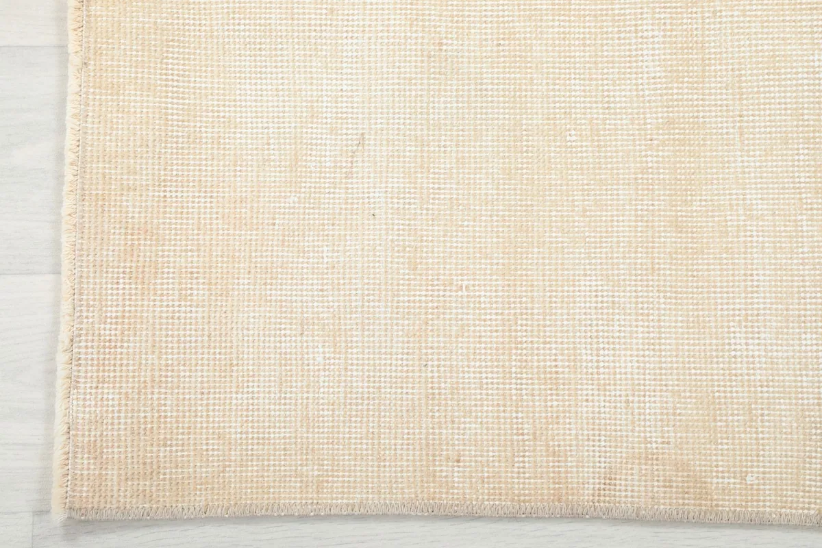 Close-up of the back of the rug, showing the cotton foundation and knotting detail.