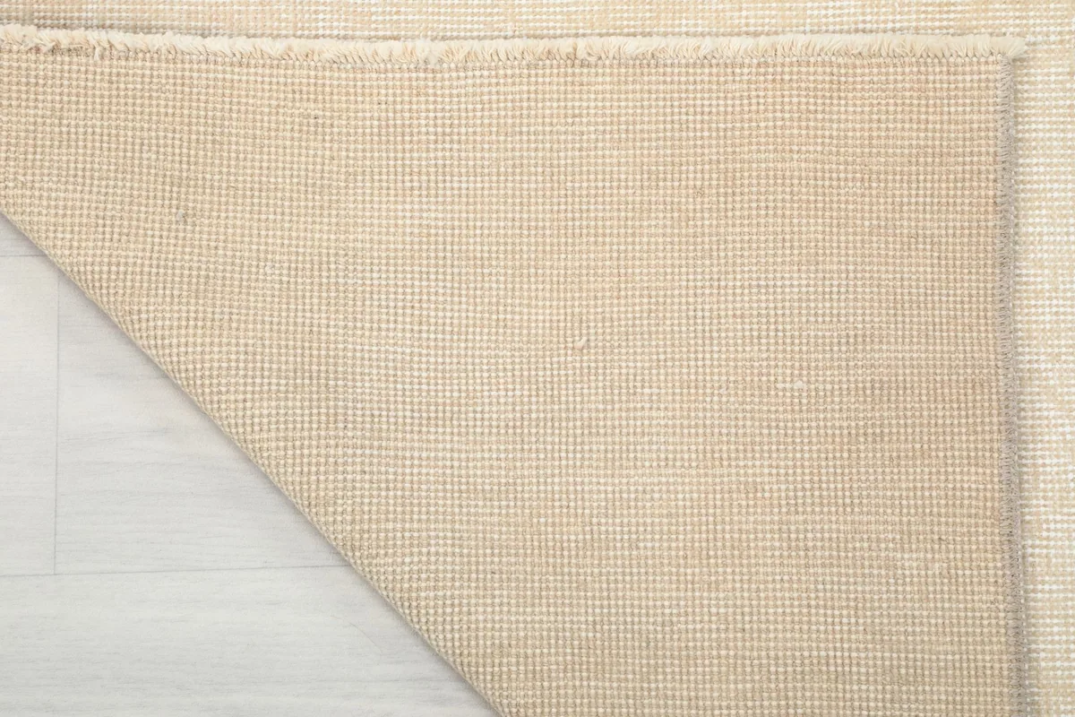 Full view of the back of the rug, revealing the woven cotton foundation.