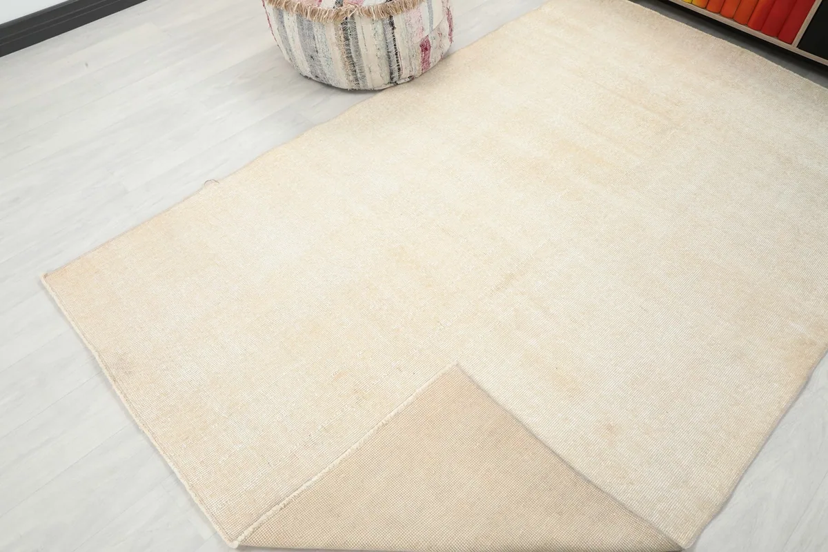 Corner of the rug folded to show both the pile and the reverse side.