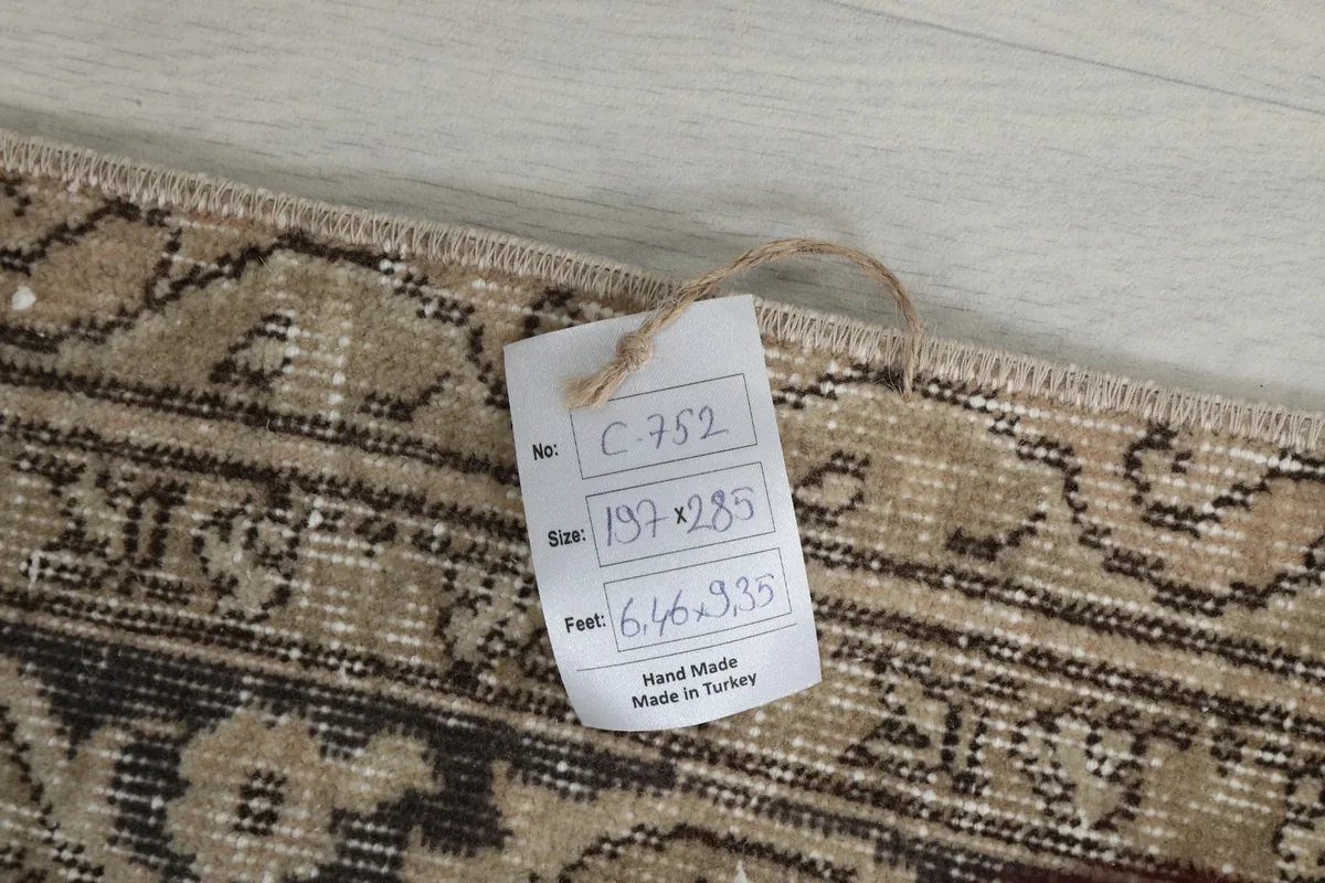 Tag showing the rug's dimensions in centimeters and feet, and origin, attached to the rug
