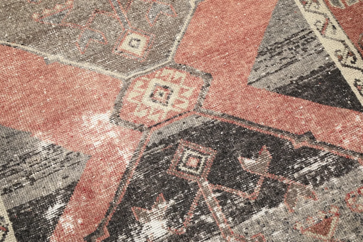 Close-up detail of the rug's central design, showcasing the hand-knotted texture and color shifts.
