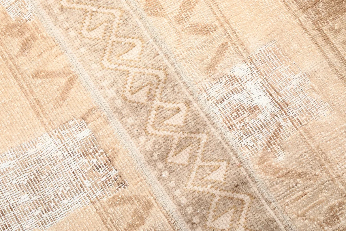 Close-up of the central geometric motifs and texture of the hand-knotted wool pile