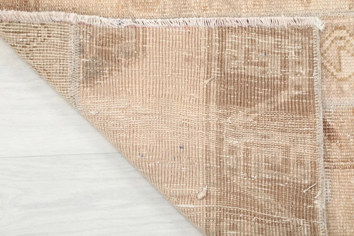 Underside view of the rug, revealing the hand-knotted cotton foundation