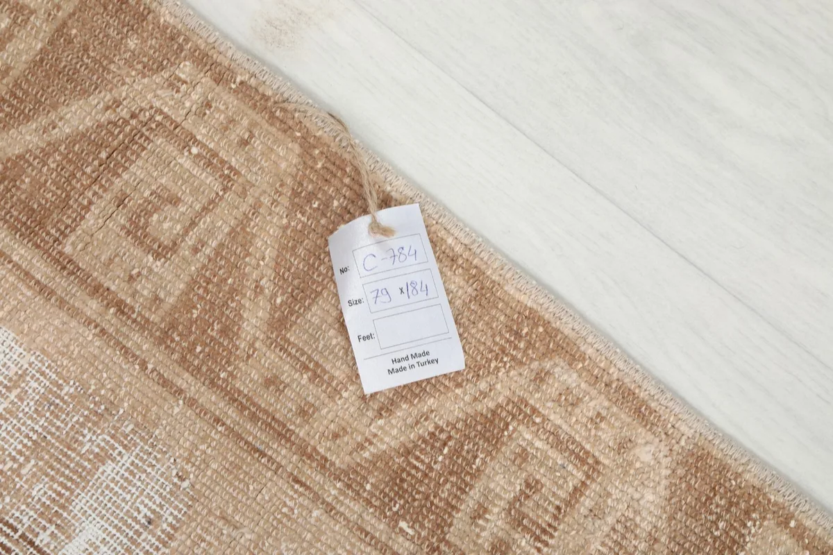 Close-up of the rug with a product tag showing details like size and origin