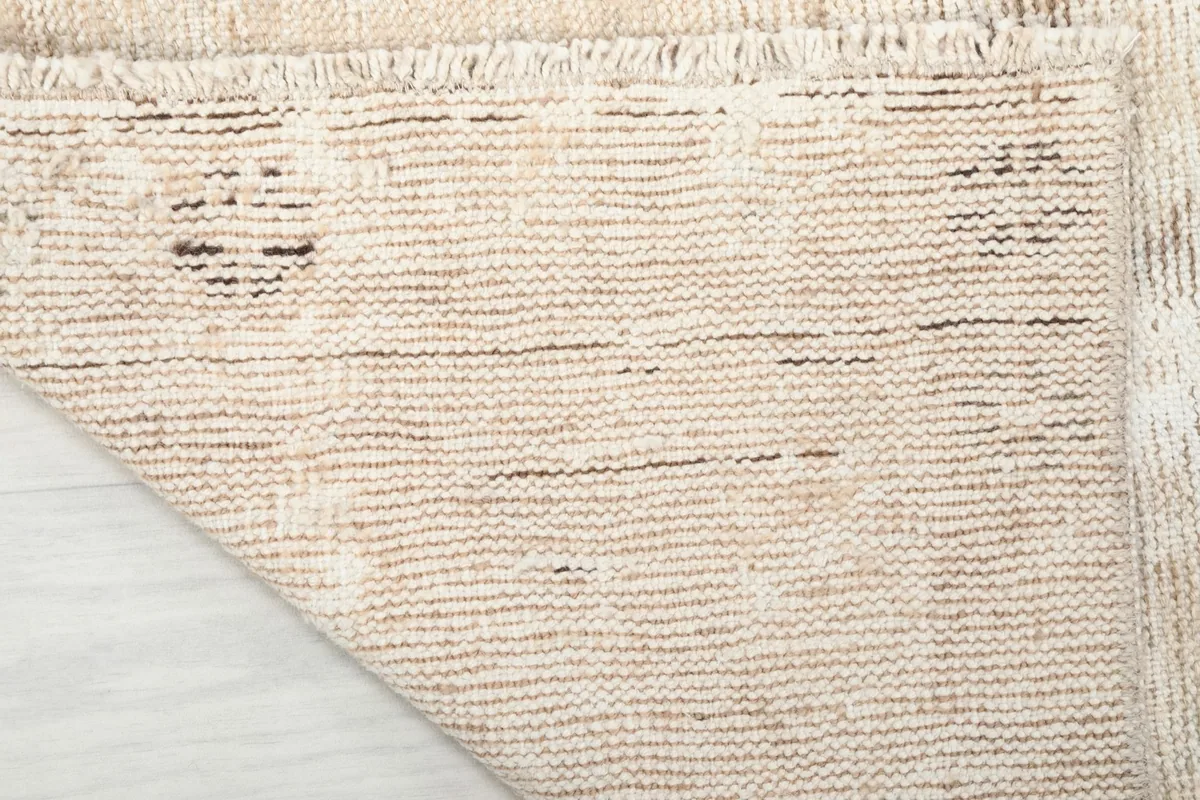 Close-up of the rug's back, showcasing the tightly woven cotton foundation and fringes