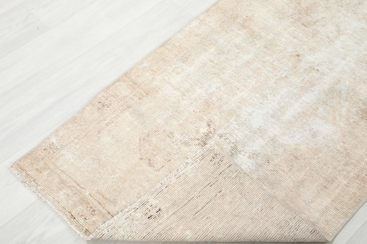 Corner of the rug folded to show the hand-knotted construction and back of the rug
