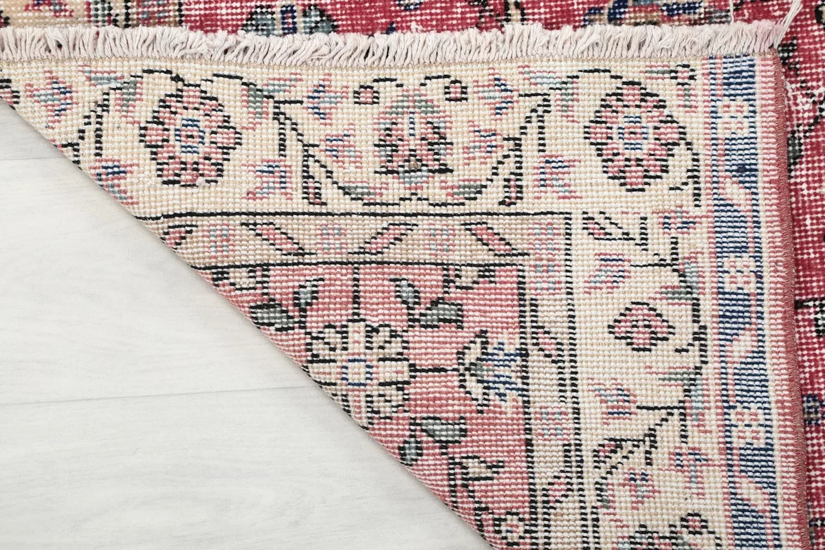 Close-up of the rug's underside, showing the intricate hand-knotting and cotton foundation.