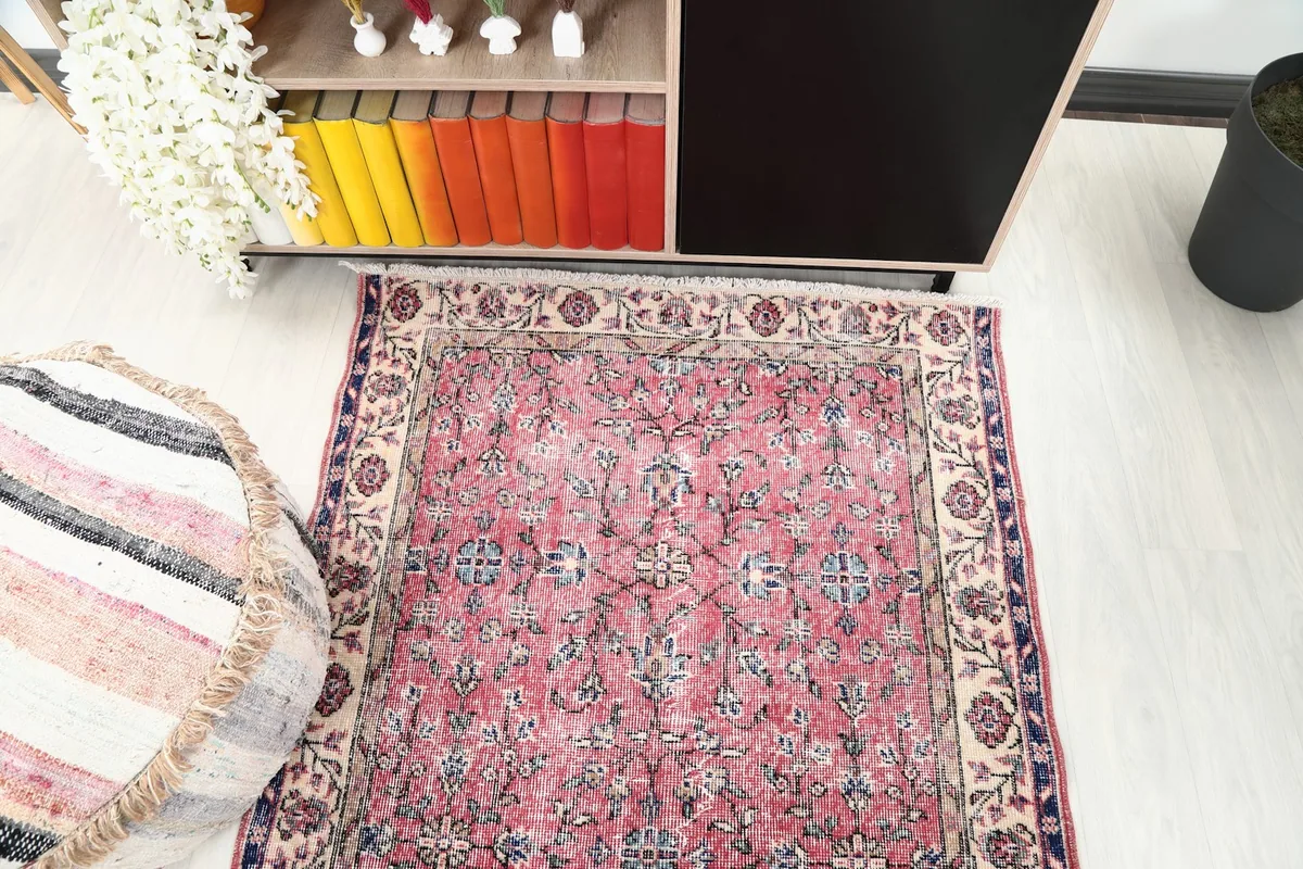 Tight overhead shot of the rug's center and a corner, highlighting the rose and blue floral motifs.