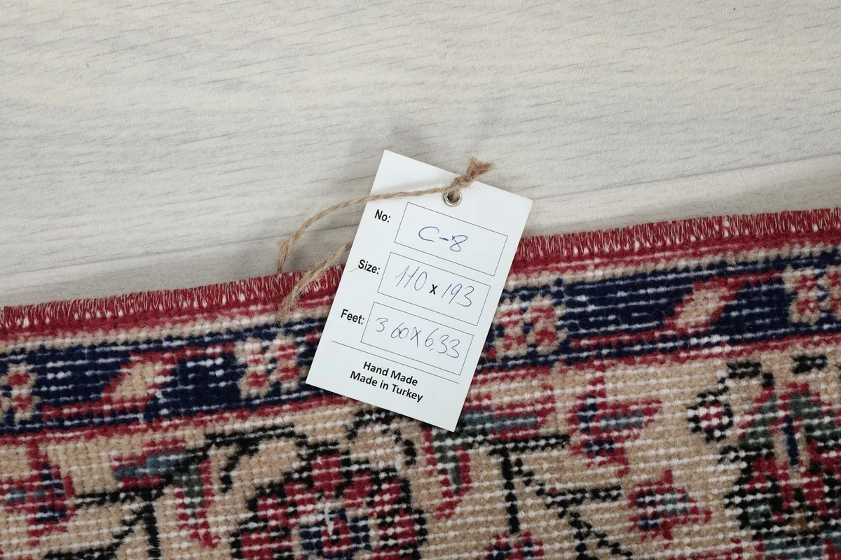 Product tag on the rug showing size in centimeters and inches, confirming it is hand-made in Turkey.