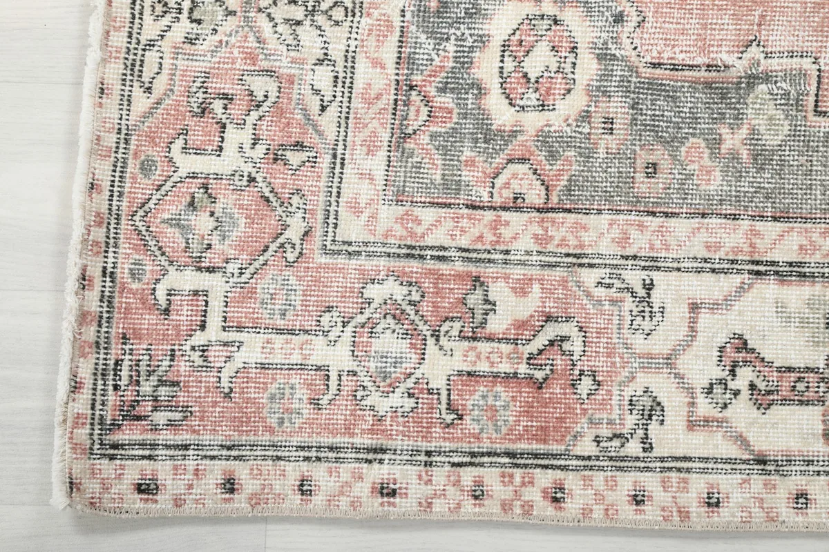 Corner detail showing the intricate border design and fringe of the rug