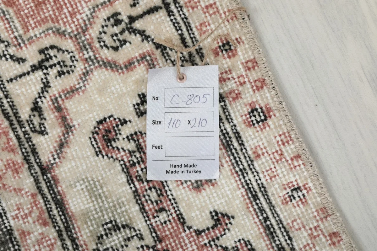 Product tag showing the rug's dimensions in centimeters and 'Hand Made Made in Turkey'