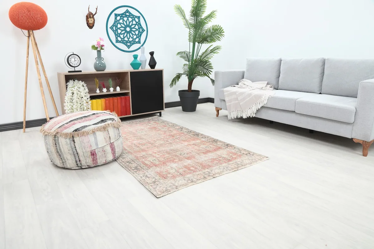 Angle view of the rose and gray vintage rug in a living room, showing its size relative to furniture