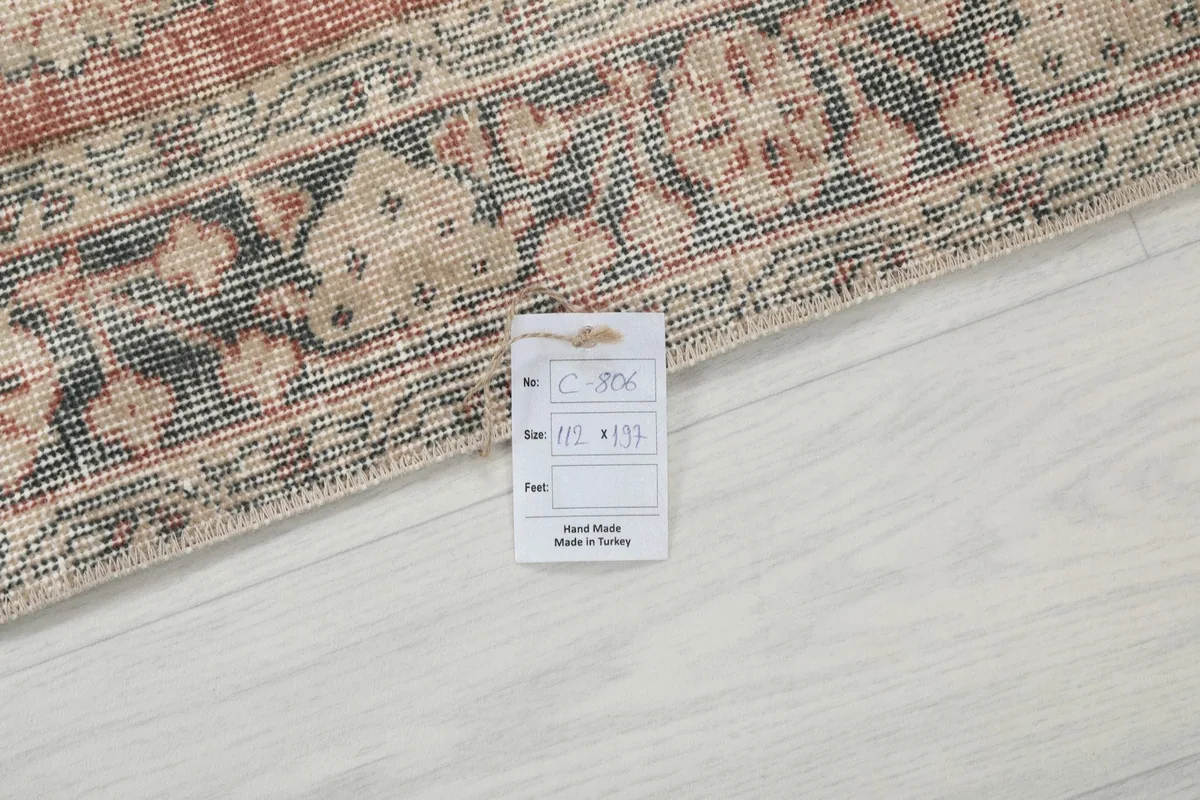 Rug tag displaying the dimensions 112 x 197 cm and origin as hand-made in Turkey