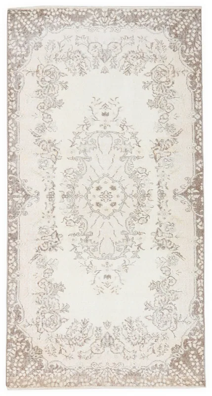 Full top view of the vintage cream and brown Anatolian wool rug on a white background