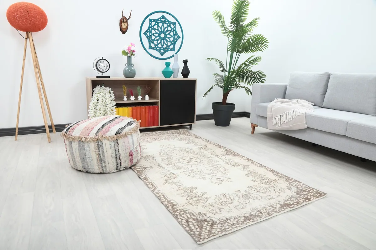 Angled view of the cream and brown floral rug in a room setting, showing its placement