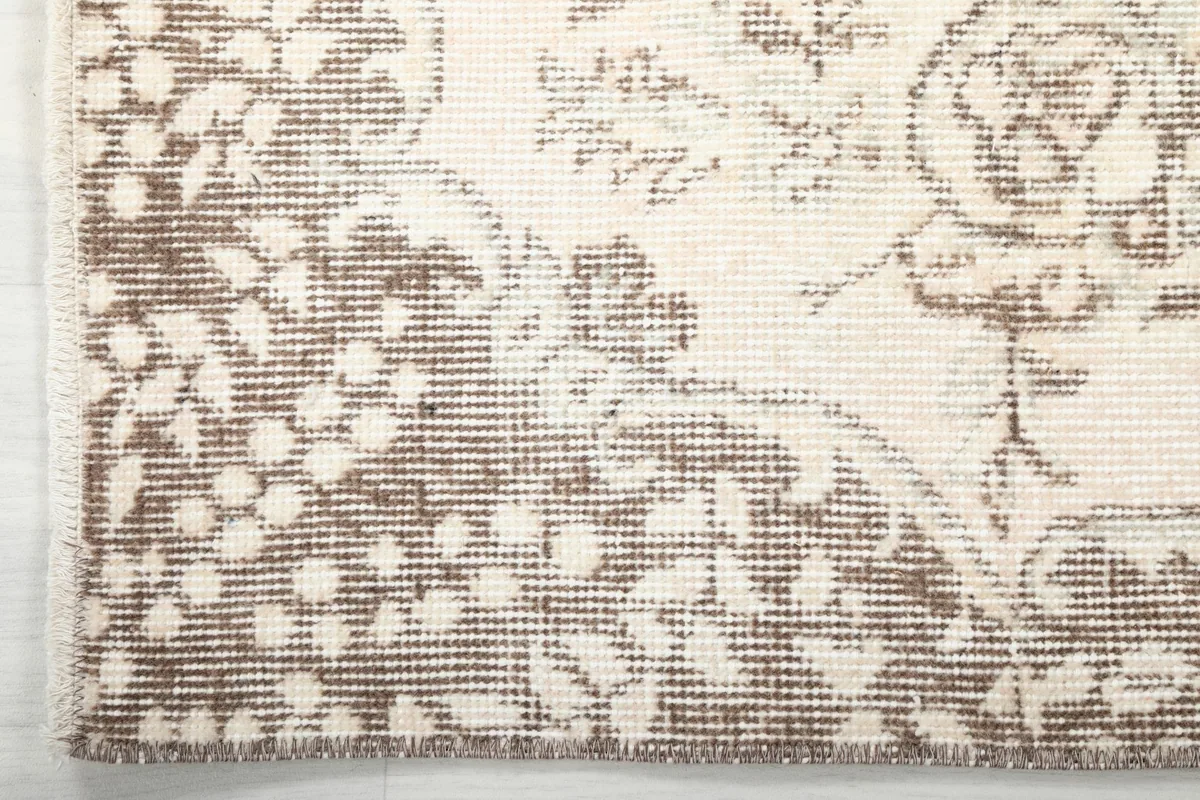 Detailed view of the rug's border pattern and the edge of the hand-knotted pile
