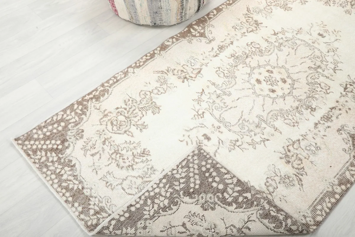 Corner of the rug folded back to show the cotton foundation and density of the knots