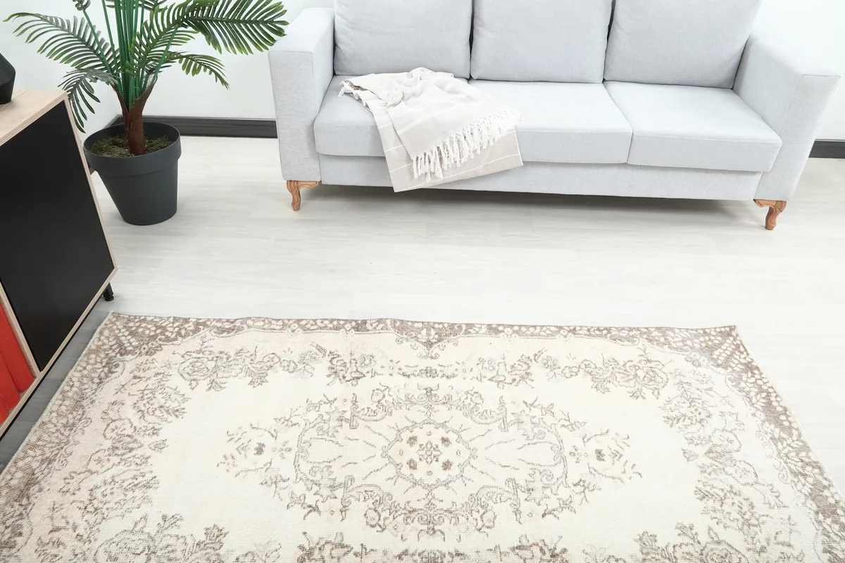 Overhead view of the rug's design and colors in a room, with a gray sofa in the background