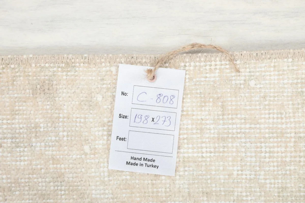 Product tag attached to the rug's back, displaying the size (198x273 cm) and origin.