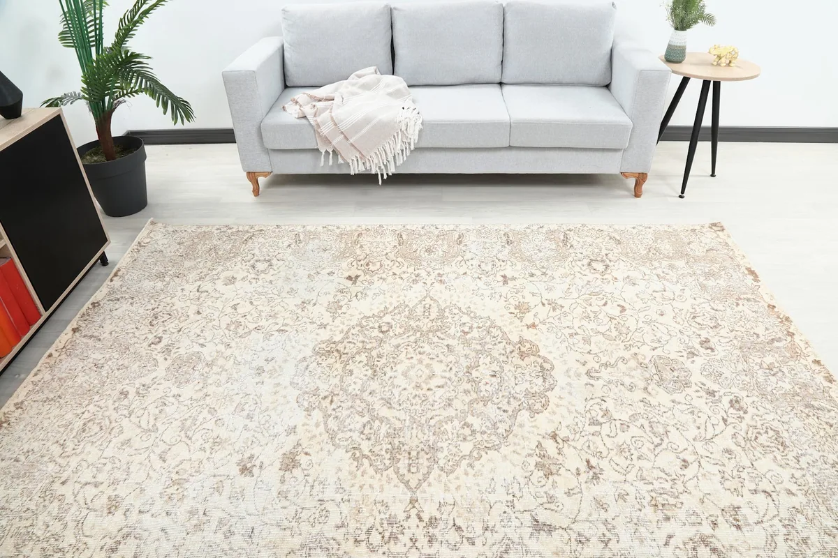 Overhead view of the rug's central medallion and field in a room with a sofa.