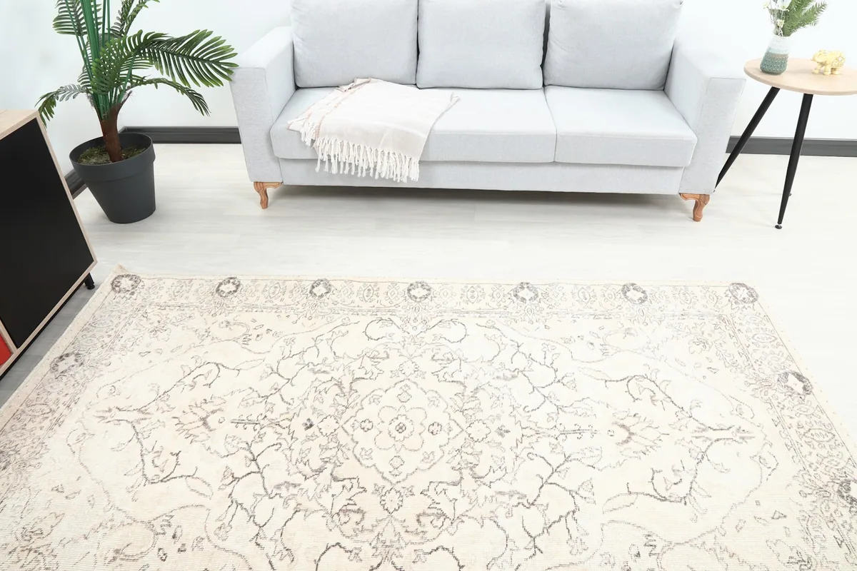 Overhead view of the rug's center and one end, with a gray sofa in the background