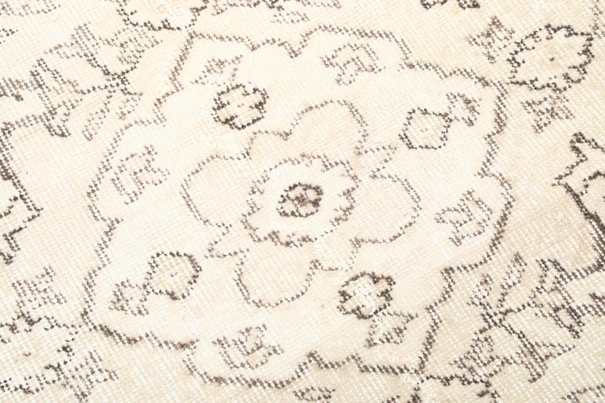 Close-up of the distressed wool pile and intricate gray floral design
