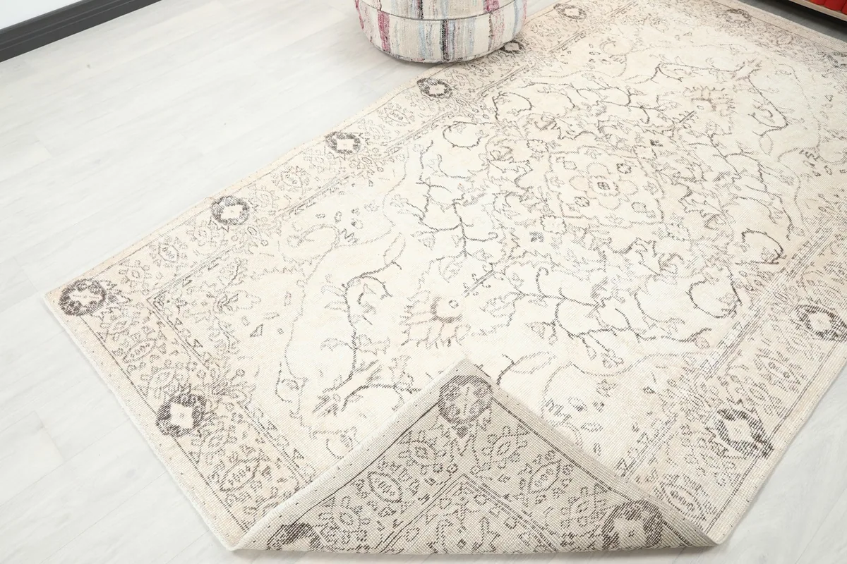 Corner of the rug folded back to reveal the cotton foundation and reverse side