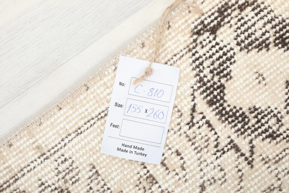 Close-up of the rug's reverse side with a tag indicating origin and size
