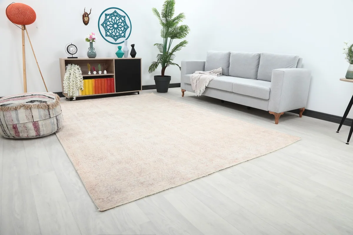 Angle view of the large vintage rug in a living room, showcasing its placement beneath a sofa.